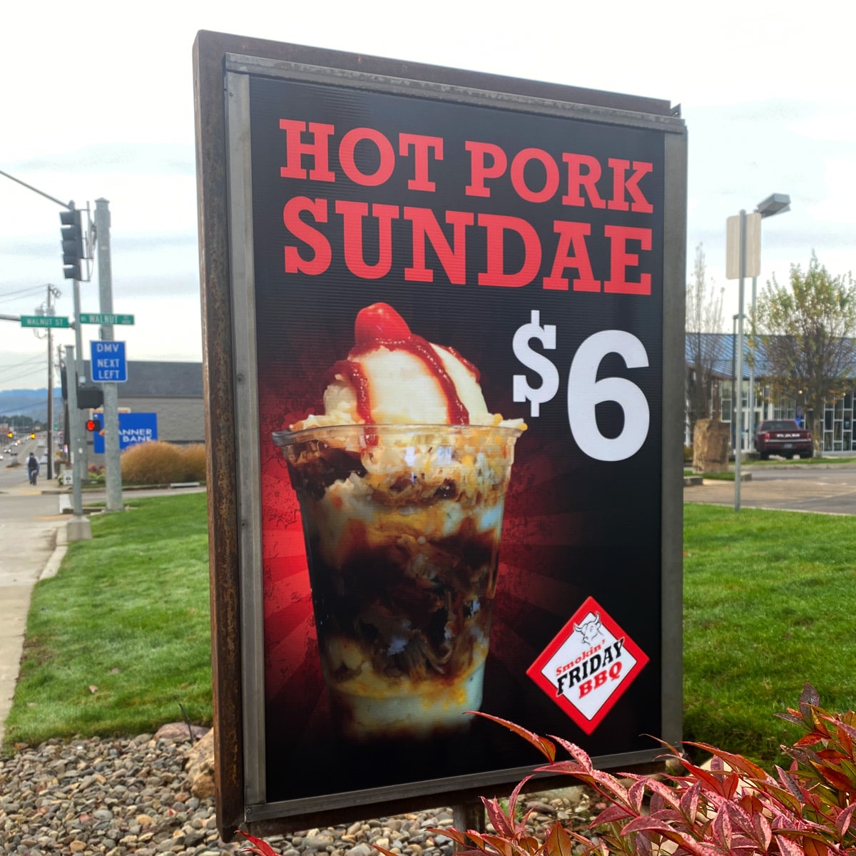 Street sign for promoting Hot Pork Sundae at Smokin Friday BBQ.